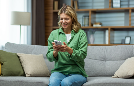 Woman sitting on a sofa using a smartphone at home