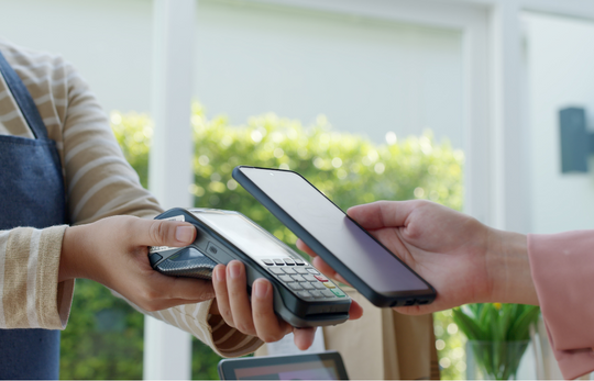 üye iş yerinde pos cihazında ödeme yapan bir el