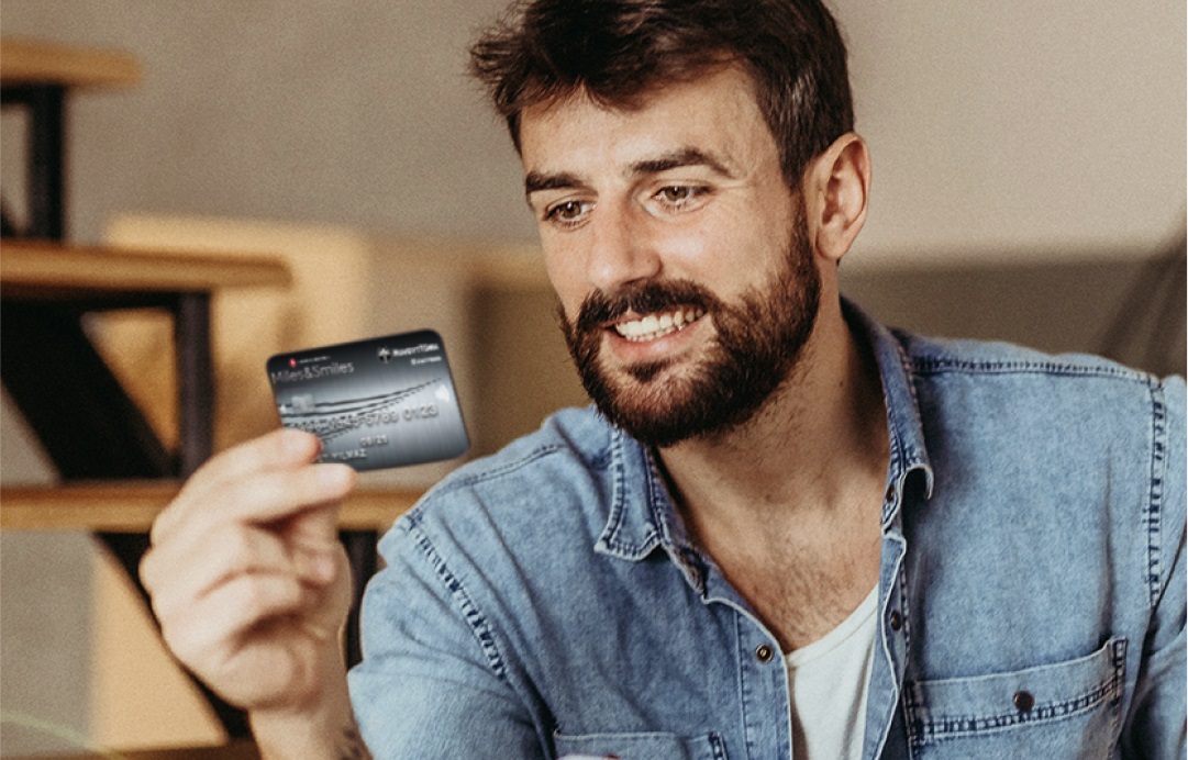 man holding a credit card and smiling indoors