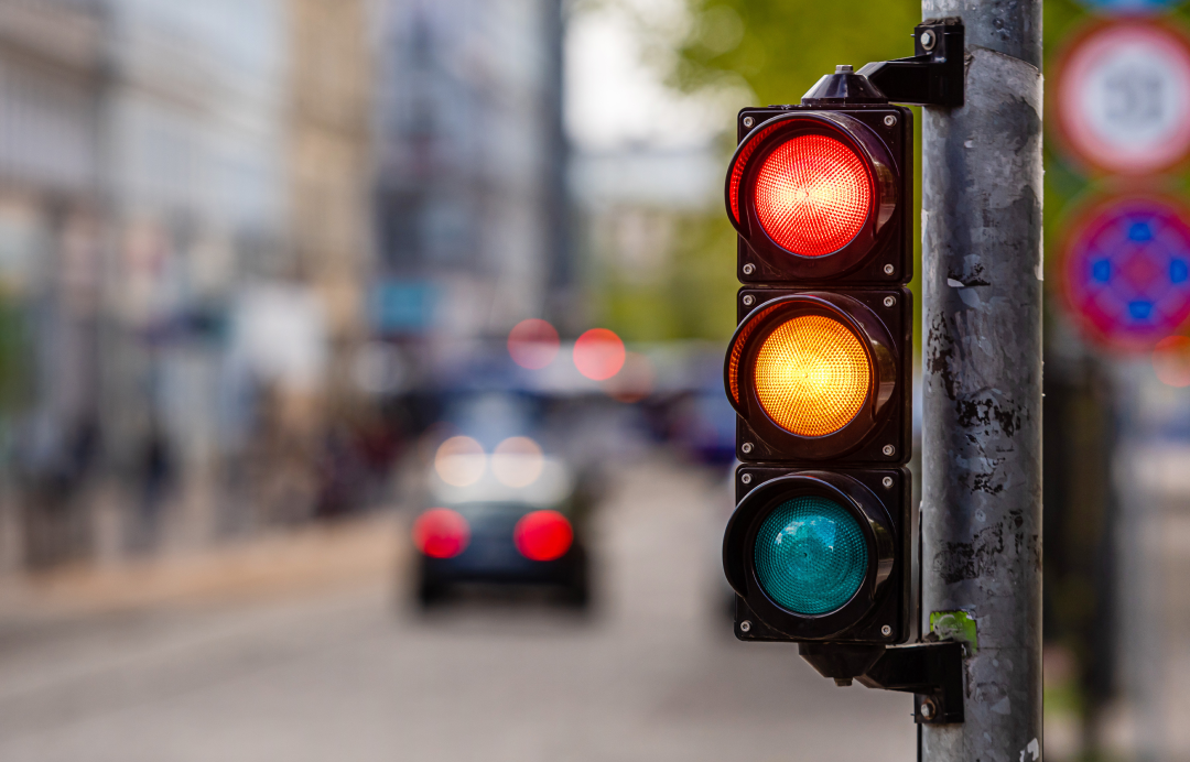 traffic light showing red yellow and green on a city street