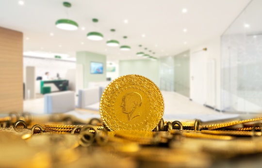 Gold coin and jewelry on a surface with blurred indoor background