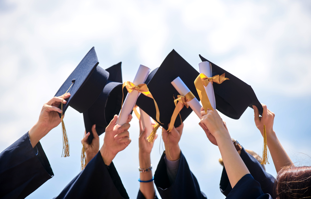 Students raising their graduation caps