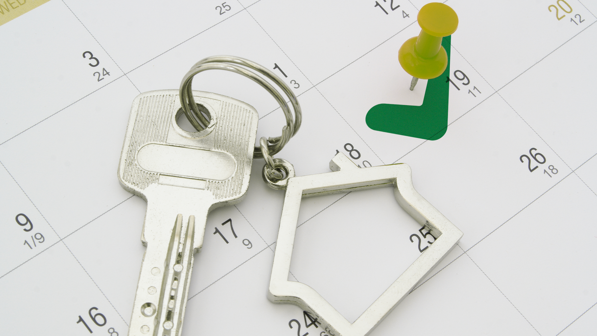 a house key with a house-shaped keychain on a white calendar page