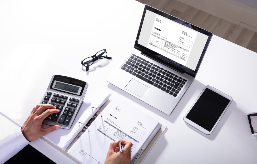 someone who works on a computer with a calculator and files
