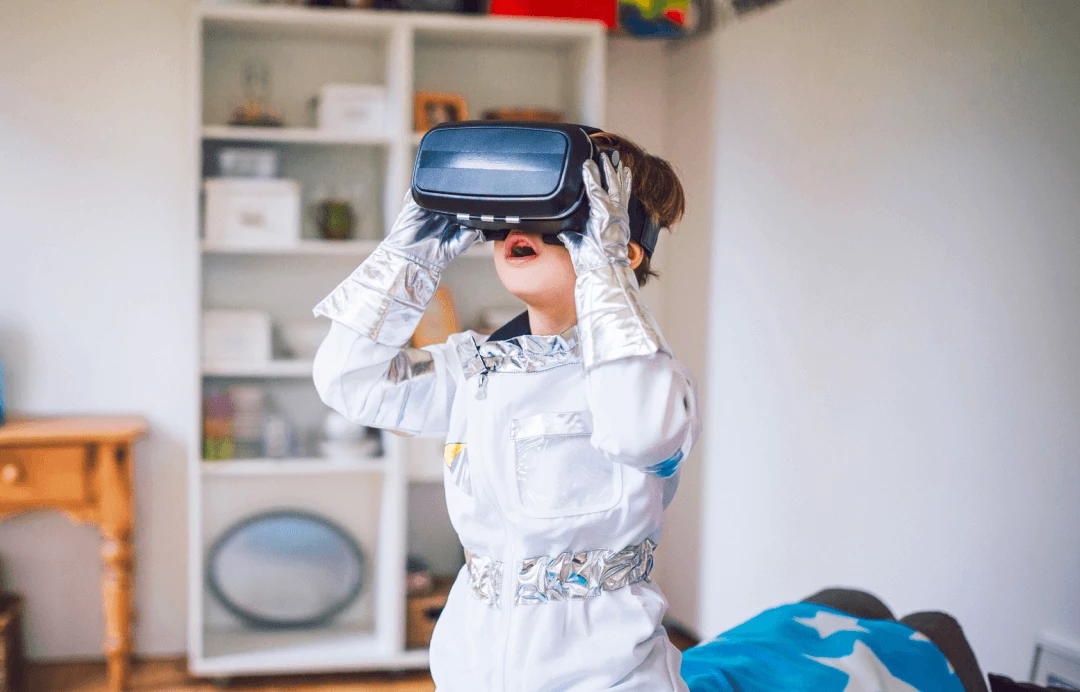 A child wearing a virtual reality headset and an astronaut costume
