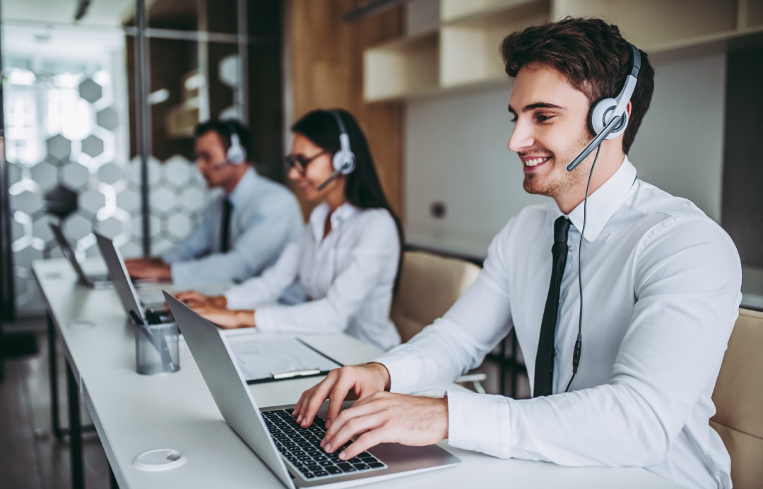 Call center agents conducting customer interviews while using headphones at their computers