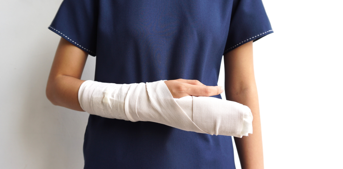 Person wearing a sling supporting an injured arm in bandage