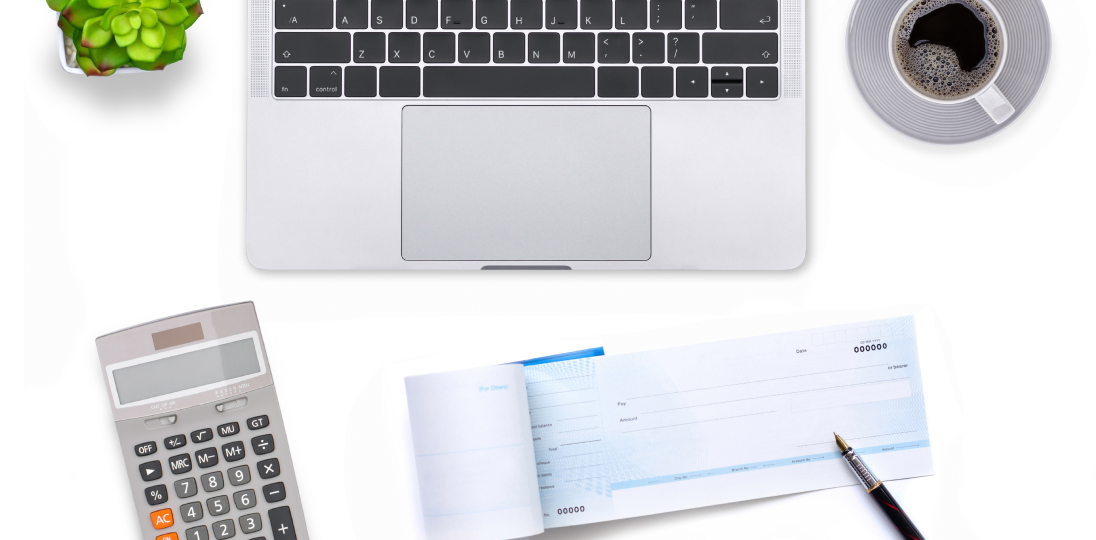 a checkbook and pen lying in front of the computer