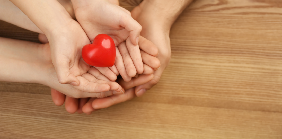 hands holding a small heart figure
