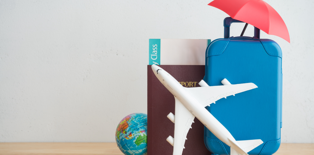 suitcase passport and airplane model with umbrella symbolizing travel insurance