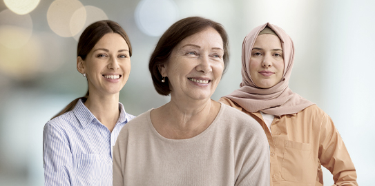 Three woman of different ages smiling and standing together