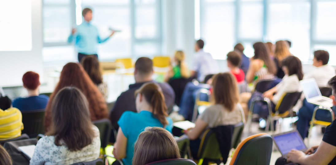 People attending a seminar with a speaker presenting at front