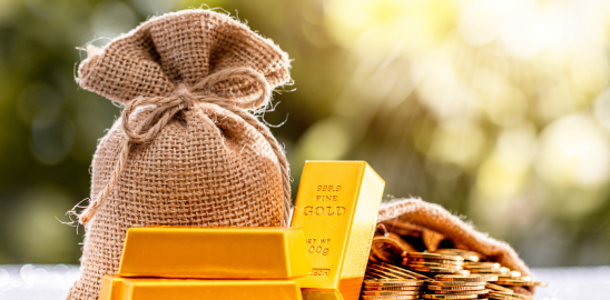 Gold bars and coins next to burlap money bag