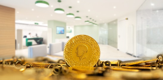 Gold coin and jewelry on a surface with blurred indoor background