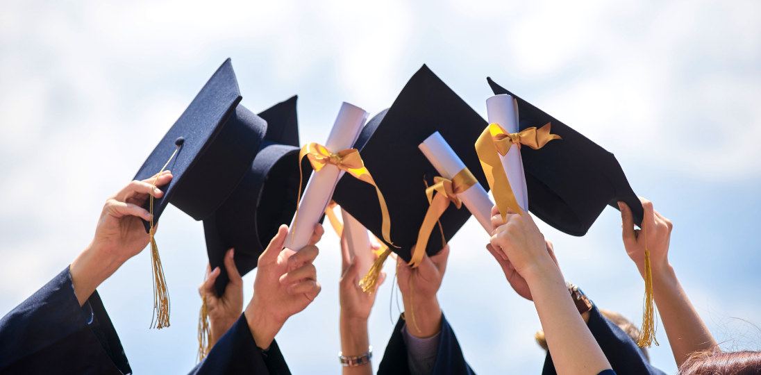 Students raising their graduation caps