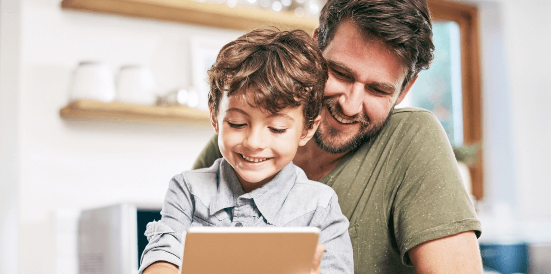 father and son looking at the tablet in their hands