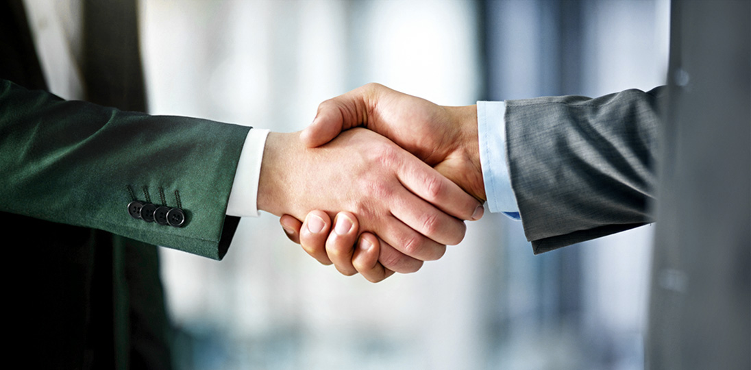 Two business professionals shaking hands in agreement